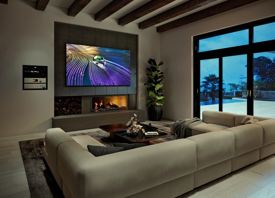 A modern living room with a 4K Sony TV mounted above a fireplace. 